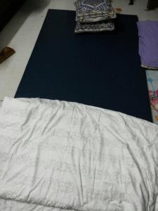 a bed with a white comforter and a pillow at Moonshadow in Sungai Kolok