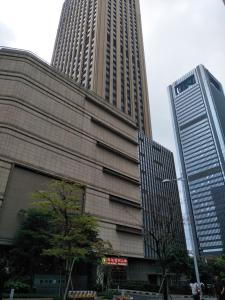 a tall building with two tall skyscrapers in a city at Pazhou Angda International Aparthotel Canton Fair Branch in Guangzhou +65 photos