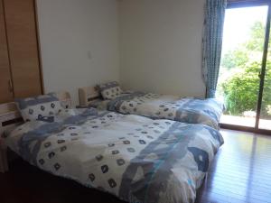 two twin beds in a room with a window at Sora-mame in Yakushima