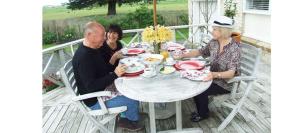 Un groupe de personnes assises autour d'une table sur une terrasse couverte dans l'établissement Miranda Homestead B&B, à Miranda