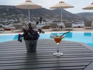 a drink sitting on a table next to a pool at Krotiri Bay -adults only in Parikia