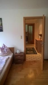 Schlafzimmer mit einem Bett und einer Tür, die zu einem Bad führt in der Unterkunft Ferienhaus Moser in Bad Gastein