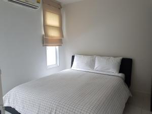 a bedroom with a bed with white sheets and a window at Paknampran 2 Bedrooms Pool Villa in Pran Buri