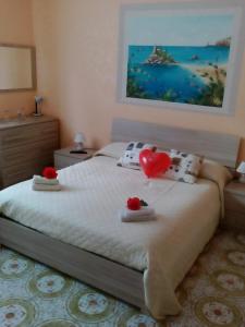 Un dormitorio con una cama con dos corazones. en Beb I Delfini Di Casa Paola, en Mascali