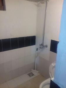 a bathroom with a toilet and black and white tiles at Pyramid International Guest House in Islamabad
