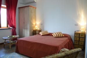 1 dormitorio con 1 cama con colcha roja en Monvillone, en Cereseto