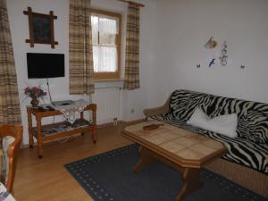 een woonkamer met een bank met zebraprint en een tafel bij Schwaigerhof in Grassau