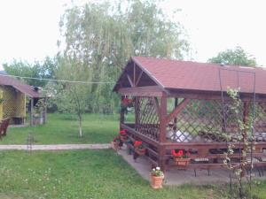 a wooden gazebo with flowers in a yard at Vila Vlad in Târgu Neamț