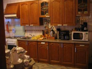a kitchen with wooden cabinets and a white microwave at Vila Vlad in Târgu Neamț