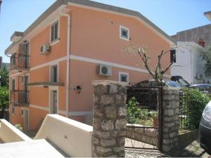 a orange building with a gate and a fence at Apartment Stana in Petrovac na Moru