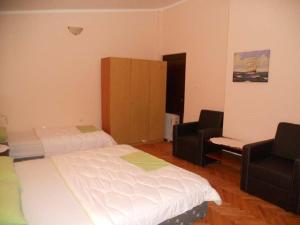 a hotel room with two beds and two chairs at Apartment Stana in Petrovac na Moru