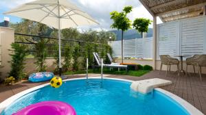 a pool with a soccer ball and an umbrella at Votsalo Suites in Skala Potamias