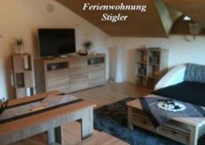 un soggiorno con un divano e una TV di Ferienwohnung Stigler a Eisenberg