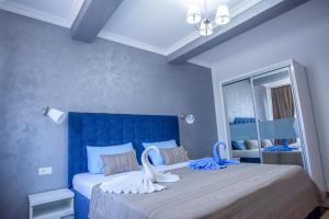 ママイアにあるCosmina Residenceのベッドルーム1室(青いヘッドボード、ベッド2台付)