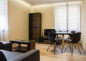 a living room with a table and chairs and a television at Apartments Gradowa in Białystok