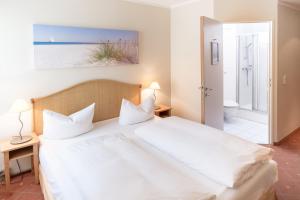 1 Schlafzimmer mit einem großen weißen Bett und einem Badezimmer in der Unterkunft Hotel Leipzig City Nord by Campanile in Leipzig