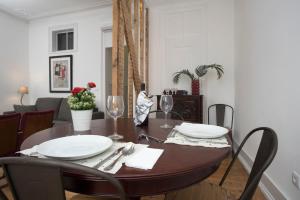 stół jadalny z dwoma białymi talerzami w obiekcie Lisboa - Belem1886 River View #2Brd #2bath w Lizbonie