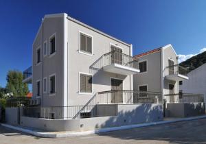 um edifício branco com varandas ao lado em G.Living 365 em Agia Effimia