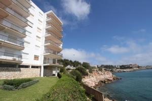 a large building next to a body of water at For a Stay Sant Jordi in Salou