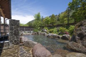 a pool of water with rocks in a yard at Nakamurakan in Takayama