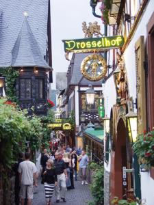 Un gruppo di persone che camminano per una strada stretta di Hotel Lindenwirt a Rüdesheim am Rhein