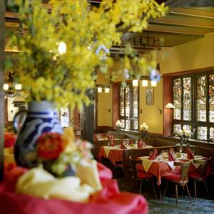 um restaurante com mesas e cadeiras e um vaso em Hotel Lindenwirt em Rüdesheim am Rhein