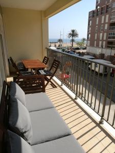 een balkon met stoelen en een tafel en uitzicht op de oceaan bij APARTAMENTO PRIMERA LINEA de la playa de Gandía in Gandía