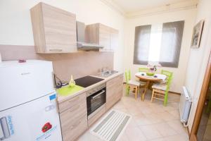 a kitchen with a white refrigerator and a table at Apartment Kampel in Koper