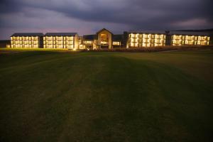 un gran edificio por la noche con un campo delante en ANEW Resort Vulintaba Newcastle, en Newcastle