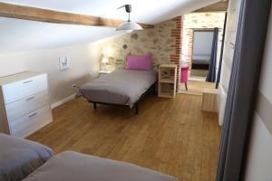 um quarto com uma cama e uma cómoda num quarto em Le Logis Du Prieure em Les Châtelliers-Châteaumur