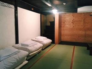 two beds in a room with a green carpet at the CUE in Tanabe