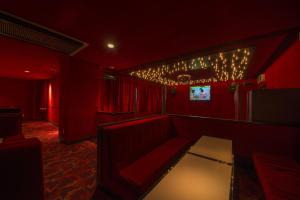 a red room with chairs and a table and lights at Nakamurakan in Takayama