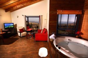 uma sala de estar com uma grande banheira num quarto em Cabin Eretz Ha-Kineret em Had Nes