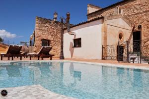 a villa with a swimming pool in front of a building at Grand Hotel La Batia in Alcamo