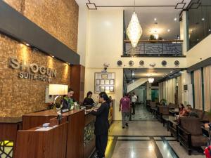 a lobby of a restaurant with people sitting at a counter at Urban Travellers Hotel in Manila