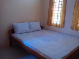 una piccola camera da letto con un letto con lenzuola blu di Chamkachuk Home a Siem Reap
