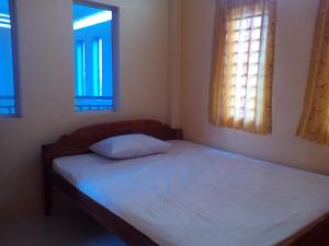 una piccola camera con un letto e due finestre di Chamkachuk Home a Siem Reap