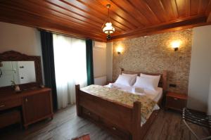 a bedroom with a bed with a wooden ceiling at Cunda Svila Otel - Adult Only in Ayvalık