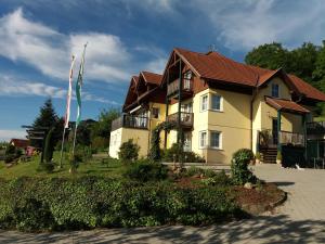 ein großes gelbes Haus mit braunem Dach in der Unterkunft Pension Dreiländerblick in Bad Gleichenberg