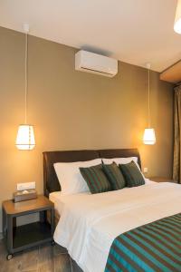 a bedroom with a bed with two pillows and a table at Kissos Apartments in Vourvourou