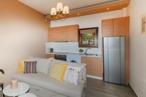 a living room with a couch and a kitchen at Kissos Apartments in Vourvourou