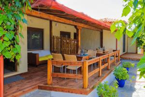a wooden deck with a table and chairs on a house at Kissos Apartments in Vourvourou