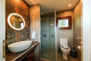 a bathroom with a sink and a toilet and a shower at Kissos Apartments in Vourvourou