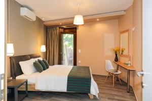 a bedroom with a bed and a table and a desk at Kissos Apartments in Vourvourou
