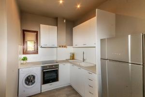 a kitchen with a washer and a sink and a refrigerator at Kissos Apartments in Vourvourou