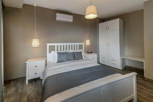 a bedroom with a white bed and white cabinets at Kissos Apartments in Vourvourou +37 photos