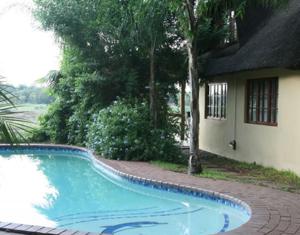 a swimming pool in front of a house at River Bank Lapa in Upington