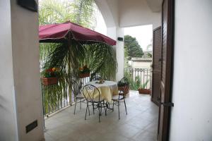 a table and chairs with an umbrella on a balcony at Residence Angelica in Oria