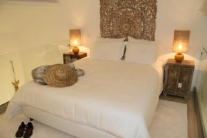 a bedroom with a large white bed with two lamps at 10 Boutique House in Alcochete