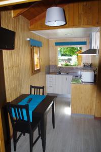 a kitchen with a dining table and a kitchen with a counter at Camping Aneto in Benasque